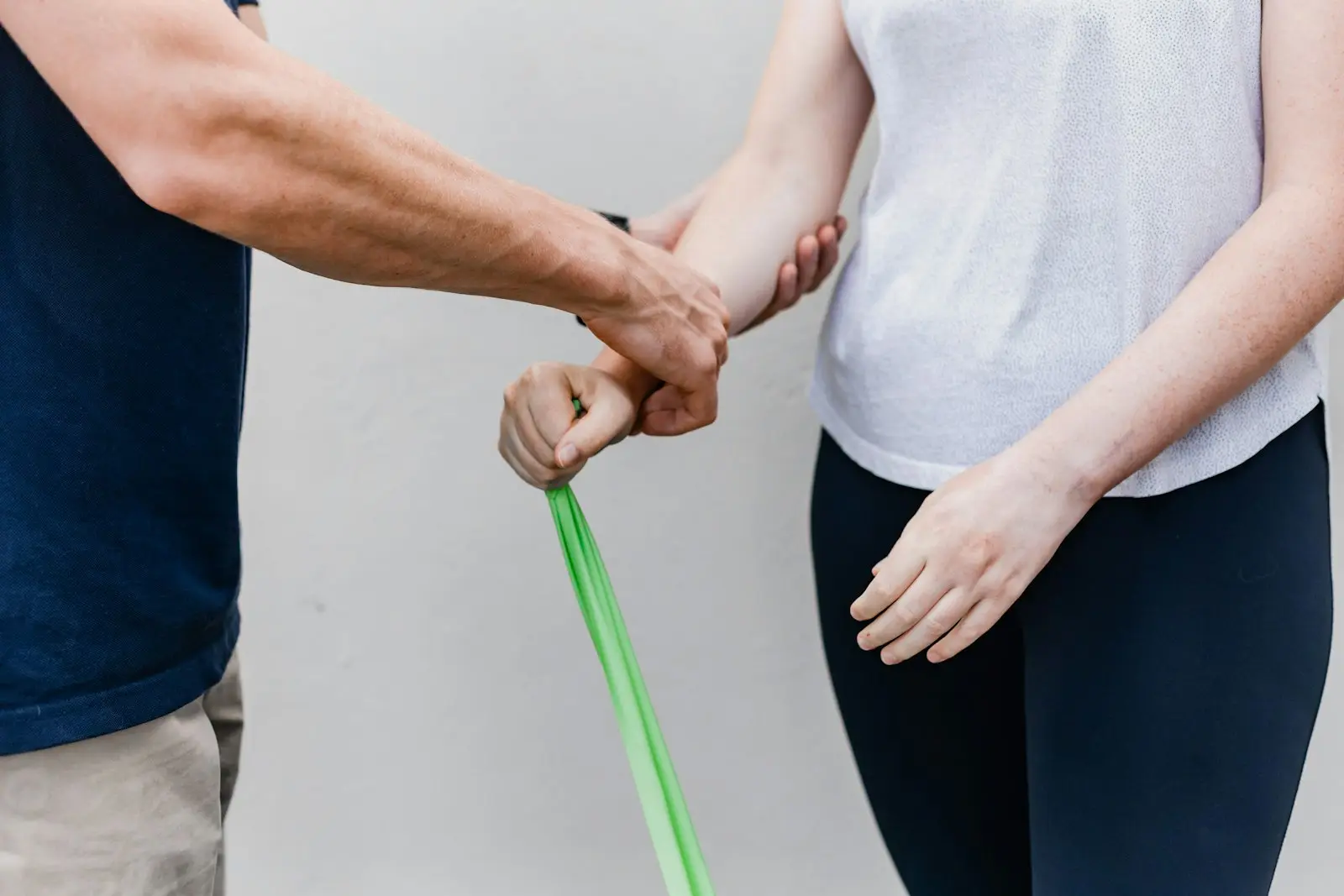 Fysiotherapeut en patiënt oefenen samen met een elastiek