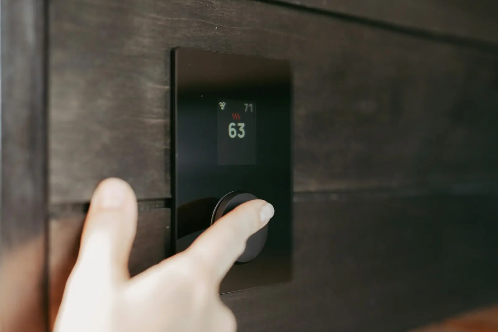 Hand stelt een digitale thermostaat in