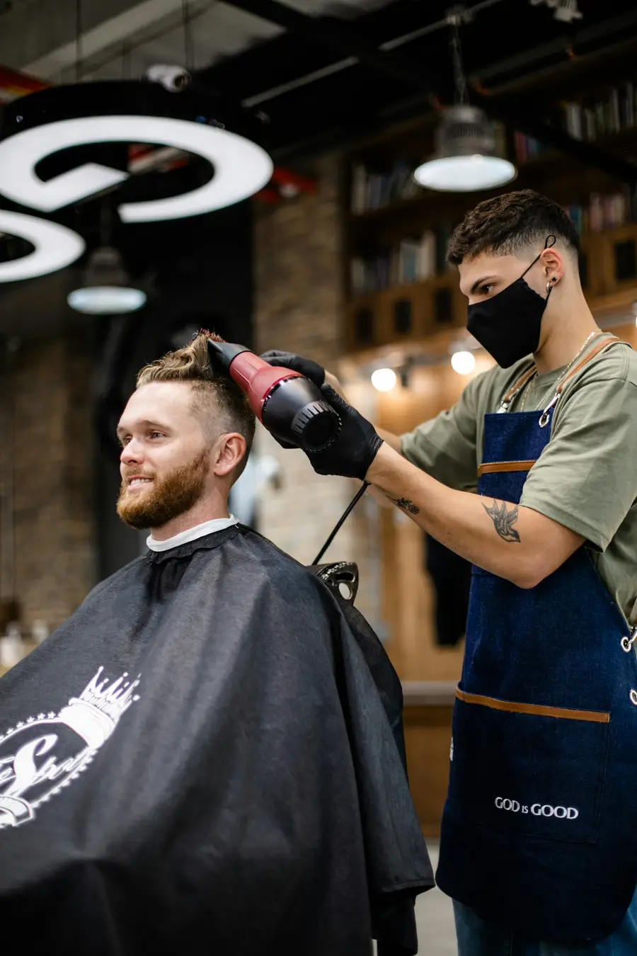 Barbier föhnt het haar van een klant in de salon