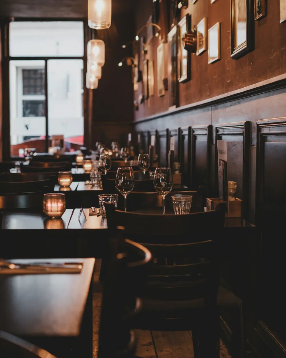 Lege restauranttafels met glazen in een donkere zaal